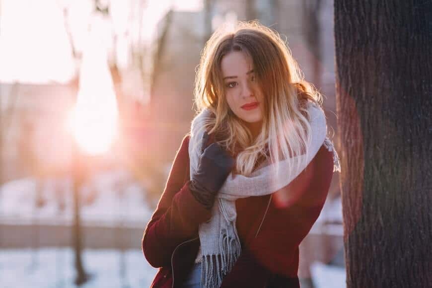 Mujer con ropa de invierno irritación en la piel por el frío